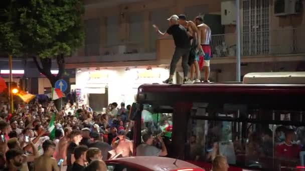 ROME, ITALIË - JULI 11, 2021: Dronken straat Italiaanse hooligans vieren overwinning van sportvoetbalteam in UEFA EURO 2020, woedende menigte geblokkeerd passerende bus op Tuscolana straat. Ventilatoren die met vlaggen zwaaien — Stockvideo