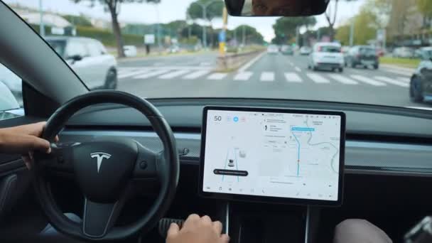 ROME, ITALY - APRIL 28, 2021: Бізнесмен їздить на новій моделі автомобіля Tesla вздовж римських вулиць, оглядає інтер "єр автомобіля Tesla з двома пасажирами в автосалоні за допомогою переднього GPS монітора. — стокове відео