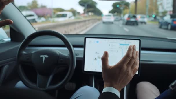 РИМ, ИТАЛИЯ - 28 апреля 2021 года: Внутренний вид инновационного автомобиля Tesla с продвинутым дисплеем сенсорного монитора, мужской привод, показывающий возможность вождения автопилота, используя только навигационные приложения — стоковое видео