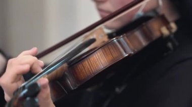 Kilisede keman çalan rahibenin yakın plan çekimleri, dindar kız kardeşin keman çalan koro şarkıları. Kemancı kendini Tanrı 'ya adadı.