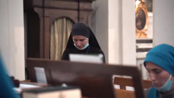 TUSCANIA, VITERBO - OCTOBER 31, 2020: Nuns in church cassocks performing religious concert in ancient catholic church of Tuscania village in Viterbo province.使用祈祷书的宗教姊妹 — 图库视频影像