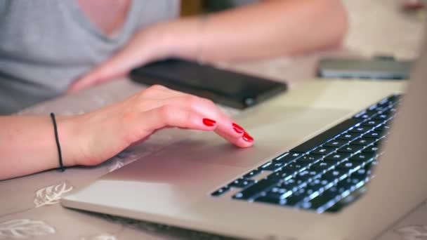 Trabalhadora do escritório feminino clicando no laptop touch pad com teclado de iluminação, mulher com manicure vermelho elegante trabalhando online com novos projetos, páginas de rolagem femininas, internet de navegação, conversando através — Vídeo de Stock