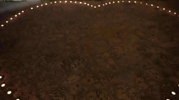 Beautiful illuminated decoration for newlywed couple first dance on wedding ceremony, burning candles arranged in heart shape on the ground. Romantic lights for wedding dance — Αρχείο Βίντεο