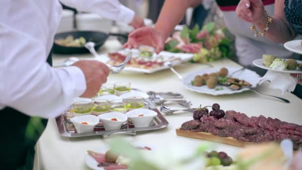 Mesa de banquete de casamento lindamente decorada com flores frescas e variedade de aperitivos e lanches servidos antes da refeição principal na recepção formal, buffet de mesa com pratos de catering e tábuas de madeira — Vídeo de Stock