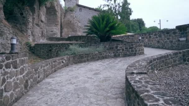 Ancient Italian residence villa with interior restaurant and courtyard, camera moving along the rising path road leading to the castle entrance. Historic landmark in the heart of Italy — Stok video