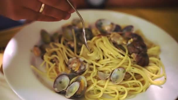 Pessoa irreconhecível usando garfo de prata para comer deliciosas massas tradicionais de espaguete italiano com frutos do mar no restaurante, macarrão caseiro cozido com mexilhões frescos temperados com salsa verde — Vídeo de Stock