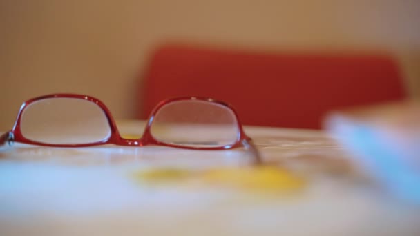 ชายอาวุโสนั่งที่โต๊ะพร้อมแว่นตาและผูกแพ็คของเงินกระดาษยูโรกับวงยืดหยุ่น ชายชราทํางบประมาณของเขาและประหยัดเงินสําหรับการลงทุนเพิ่มเติมในธุรกิจหรือ — วีดีโอสต็อก