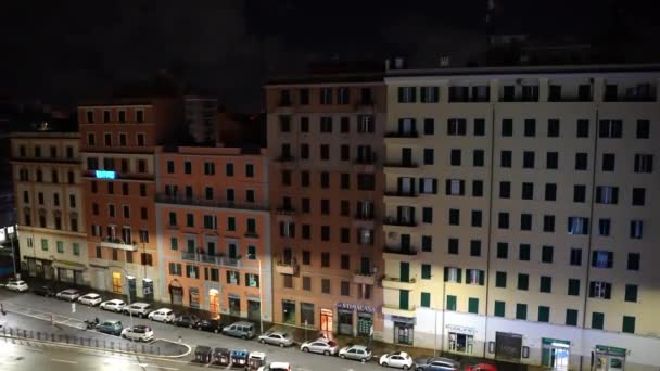 意大利罗马- 2021年2月7日：罗马市中心大街上的五彩斑斓的住宅大楼，停在大楼下的汽车，夜间闪烁着引导灯的招牌。空荡荡的街道 — 图库视频影像