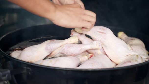 Man sätter kycklingben på bbq rutnät rostning på kol, stora kycklingben grillning för Oktoberfest picknick fest. Bayersk helg grillning, grillning kyckling för fest — Stockvideo