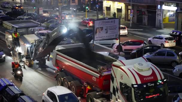 ROM, ITALIEN - 9. APRIL 2021: Schwertransporter entfernen mit Druck alten zerstörten Asphalt auf der Straße während des Autoverkehrs in der Innenstadt von Rom, Arbeiter reparieren Teile der Straße, die eine neue Schicht tragen — Stockvideo