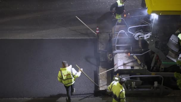 ROME, ITALIEN - APRIL 9, 2021: Lagarbetare i uniform stenläggning svart heta ångande asfalt med ångvält maskin på gatorna i Rom, reparera arbeten på natten, väg återuppbyggnad — Stockvideo
