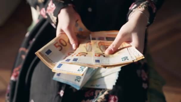 Pomyślne liczenie dochodu przez przedsiębiorczynię, kobiece ręce trzymające paczkę banknotów euro, liczenie i dzielenie 20 i 50 euro oszczędności w walucie papierowej dla różnych celów. Promocja kariery, finanse — Wideo stockowe