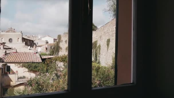 Θέα μέσα από το παράθυρο των εκπληκτικών αρχαίων ιταλικών κτιρίων του χωριού με χαρακτηριστικά αρχιτεκτονικά χαρακτηριστικά, παλιά κτίρια και σπίτια με αρκετούς πολίτες, εγκαταλειμμένες παλιές πόλεις και χωριά στο — Αρχείο Βίντεο