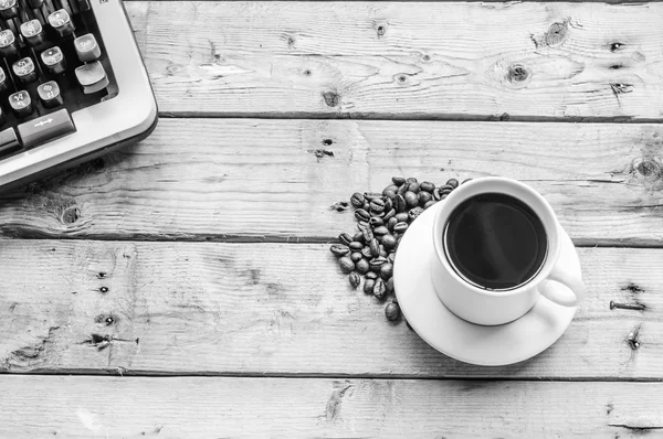 B&W kahve fincanı ve ahşap masa arka plan üzerinde kahve çekirdekleri