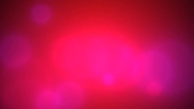 Video arkaplanı kırmızı, arka planda yuvarlak mor bokeh var. Küçük beyaz parçacıkların parlamaları resmi tamamlar.