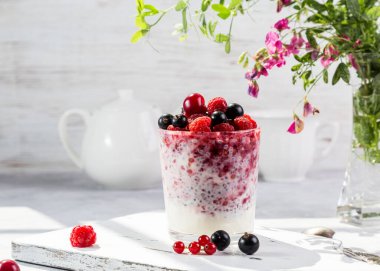 Hafif arkaplanda taze böğürtlen ve chia tohumlu yoğurt..