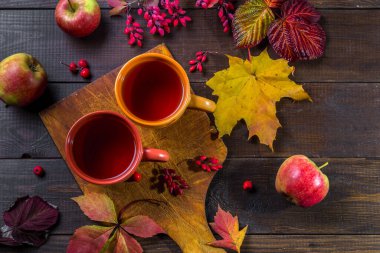 Sonbahar çayı ve sonbahar yaprakları ahşap bir masada..