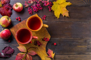 Sonbahar çayı ve sonbahar yaprakları ahşap bir masada..