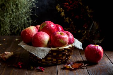 Tahta arka planda damlaları olan taze kırmızı elmalar..