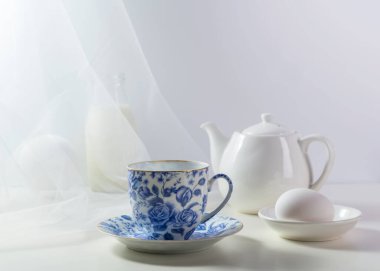 İçinde çay ve arka planda yumurta olan bir fincan. Kahvaltı konsepti.