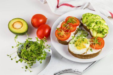 Peynirli tam buğday tostu, domates, avokado ve mikroyeşillik..
