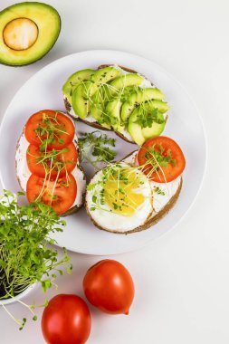 Peynirli tam buğday tostu, domates, avokado ve mikroyeşillik..