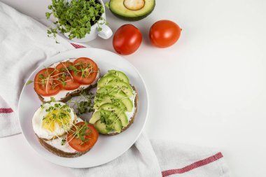Peynirli tam buğday tostu, domates, avokado ve mikroyeşillik..