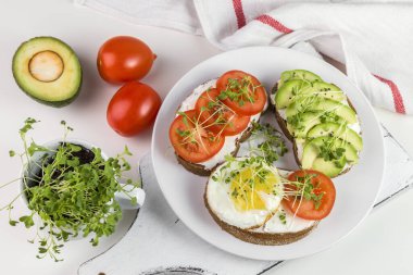 Peynirli tam buğday tostu, domates, avokado ve mikroyeşillik..