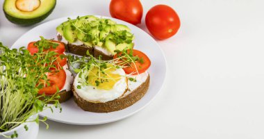 Peynirli tam buğday tostu, domates, avokado ve mikroyeşillik..