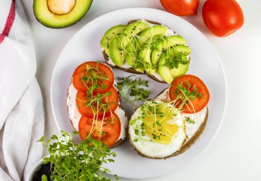 Peynirli tam buğday tostu, domates, avokado ve mikroyeşillik..