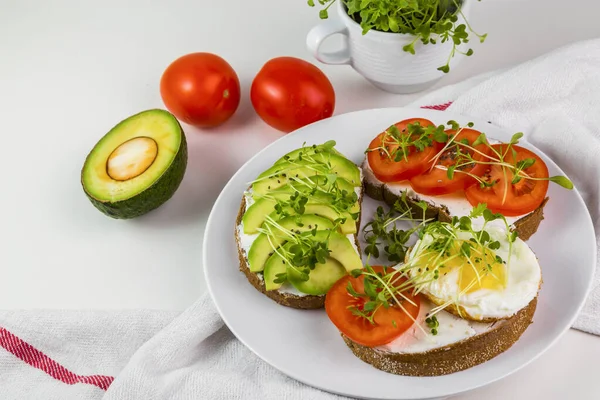 Peynirli tam buğday tostu, domates, avokado ve mikroyeşillik..