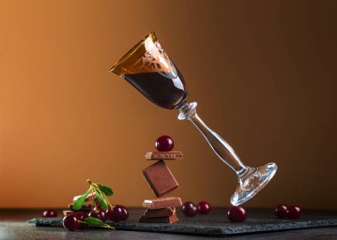 Çikolata ve kirazlı bir bardakta kiraz likörü. Dengeleme konsepti.