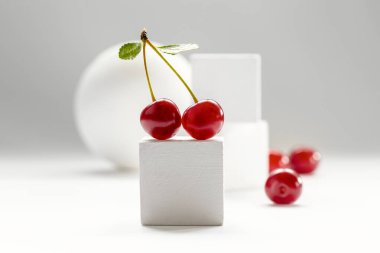 Kirazlı ve beyaz arkaplanlı modern natürmort.