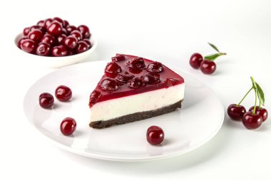 Beyaz bir masada bir tabak kirazlı cheesecake..