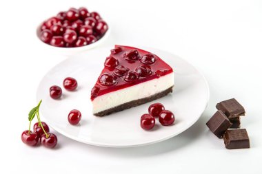 Beyaz bir masada bir tabak kirazlı cheesecake..