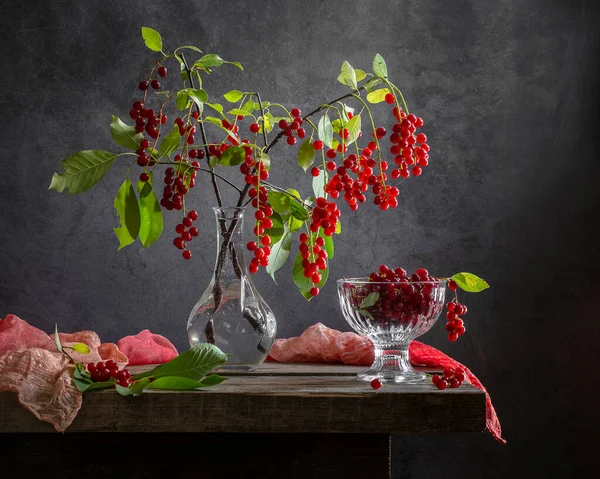 Tahta bir masadaki vazoda kırmızı kiraz..