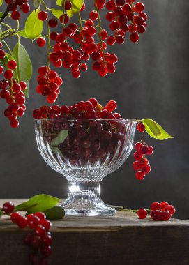 Tahta bir masadaki vazoda kırmızı kiraz..