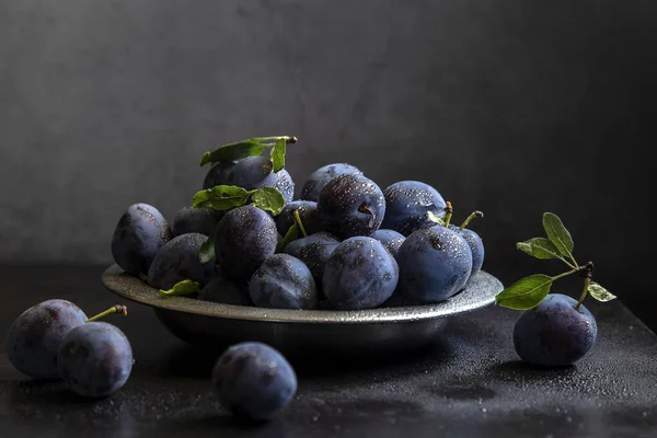 Een Volle Bord Rijp Fruit Van Pruimen Met Waterdruppels Een — Stockfoto