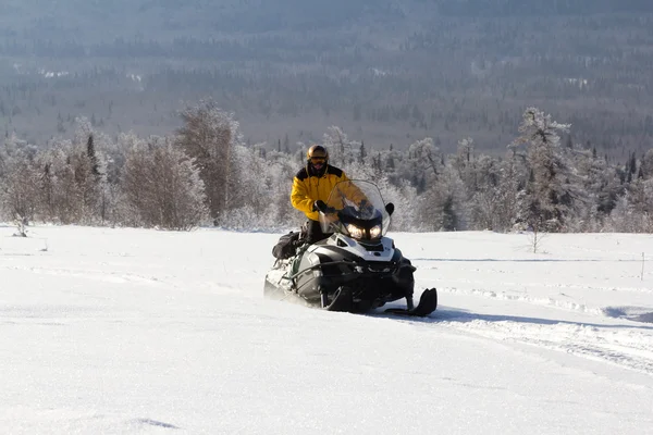 Atleta em uma moto de neve — Fotografia de Stock