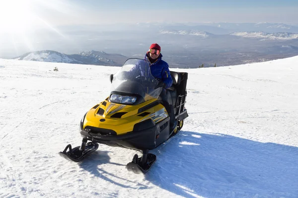 Atleta em uma moto de neve — Fotografia de Stock