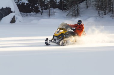 Athlete on a snowmobile. clipart