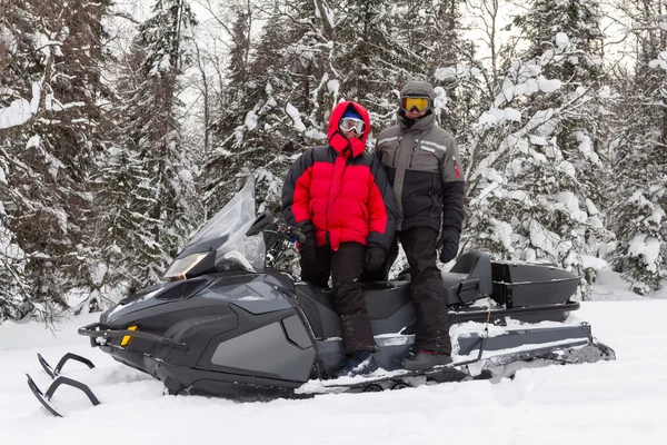 Man en vrouw op een sneeuwscooter. — Stockfoto