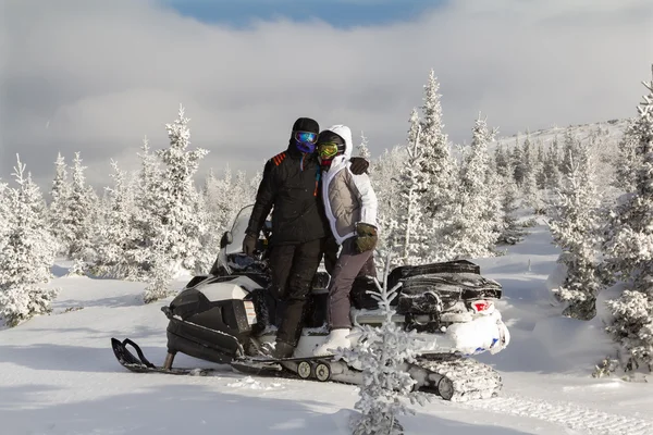 Homem e mulher em uma moto de neve . — Fotografia de Stock