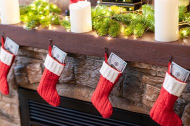 Amerikan ve Amerikan Doları Noel kırmızı çorapları Bokeh Işıkları 'ndaki şöminenin üzerinde hediyeler için.