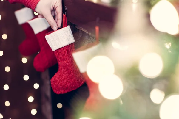 Mulher Pendurado Meias Vermelhas Natal Para Presentes Lareira Luzes Bokeh — Fotografia de Stock