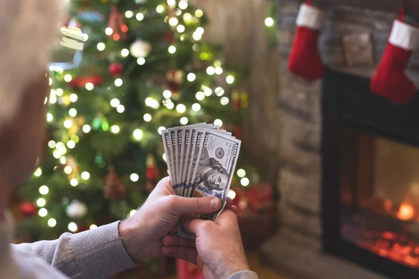 Man Räknar Amerikanska Dollar Sittande Nära Julgran Och Öppen Spis — Stockfoto