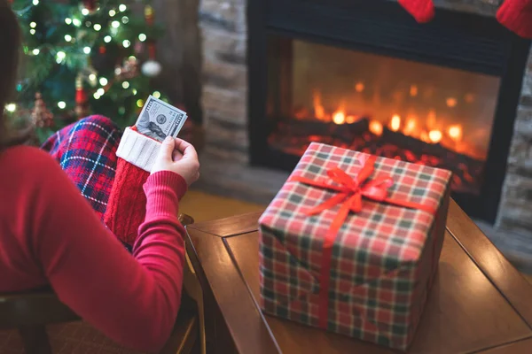 Kvinna Sätta Amerikanska Dollar Röd Julstrumpa Sitter Nära Julgran Och — Stockfoto