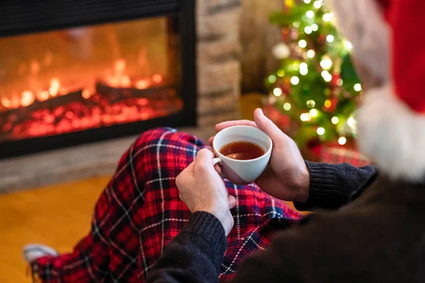 Hombre Con Taza Café Santa Claus Sombrero Sentado Calentamiento Noche —  Fotos de Stock