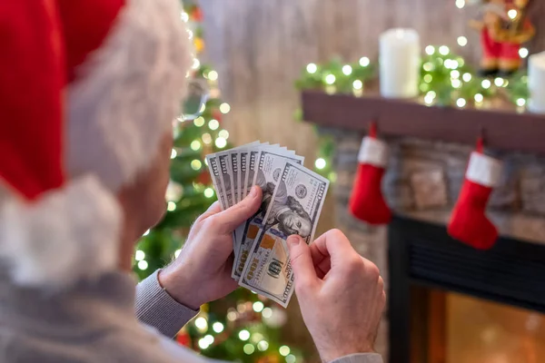 Mannen Tomtehatt Räknar Amerikanska Dollar Sittande Nära Julgran Och Öppen — Stockfoto