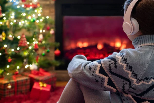 Alleen Trieste Vrouw Koptelefoon Zit Verwarmt Winters Bij Open Haard — Stockfoto